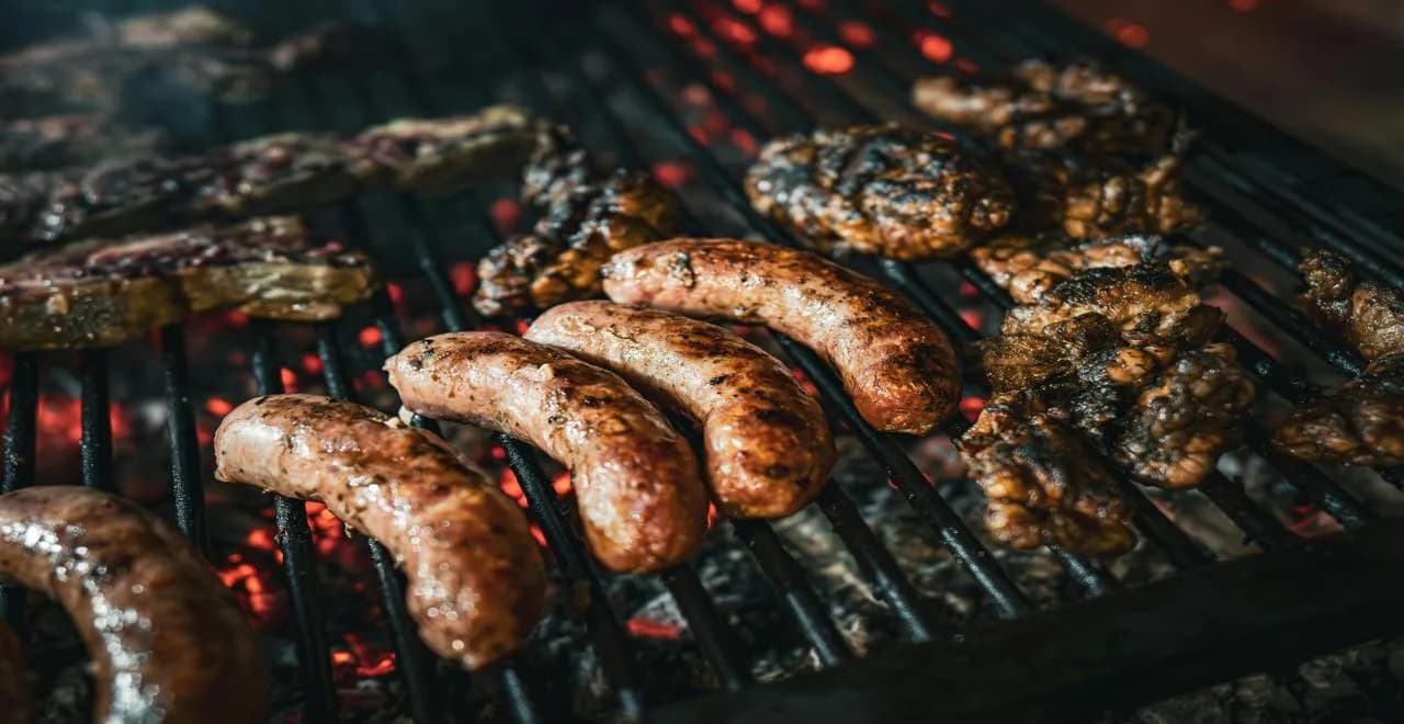 Saucisse à rôtir juteuse accompagnée d'une sauce aux oignons caramélisés, servie dans une assiette en céramique rustique