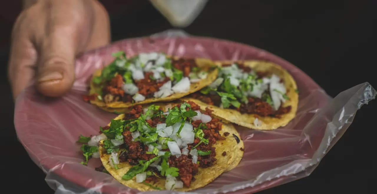 Assiette de tacos al pastor fraîchement préparés, garnis d'ananas et de coriandre